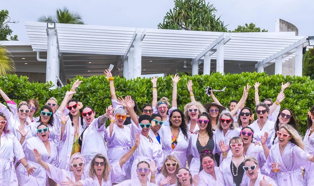 A group of She Evolves women together in matching purple robes